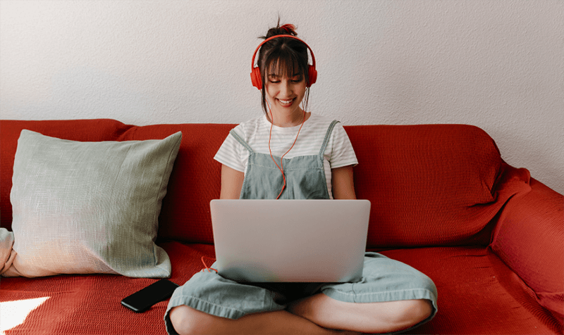 Woman working on laptop with a red headphone overhead